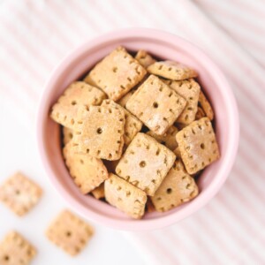 a pink bowl filled with baked crackers