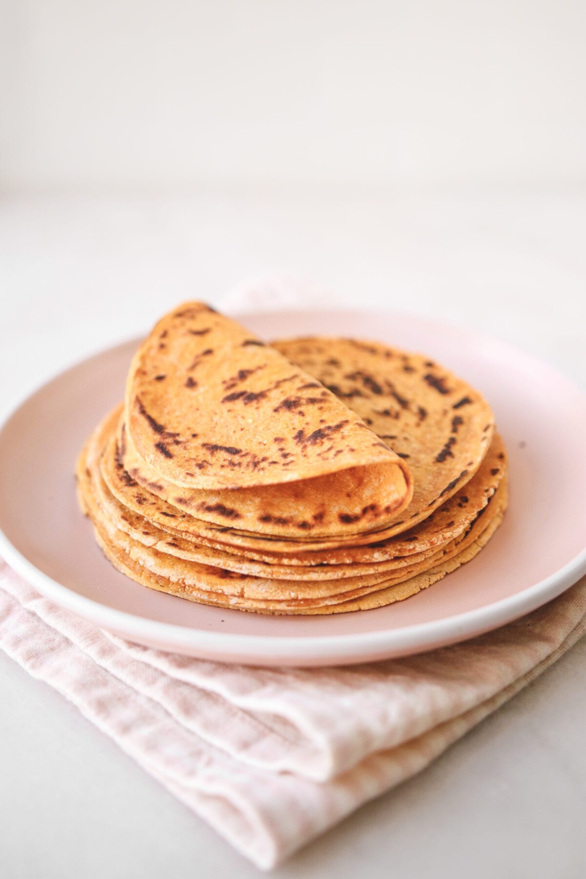 a stack of sweet potato tortillas resting on a pink plate