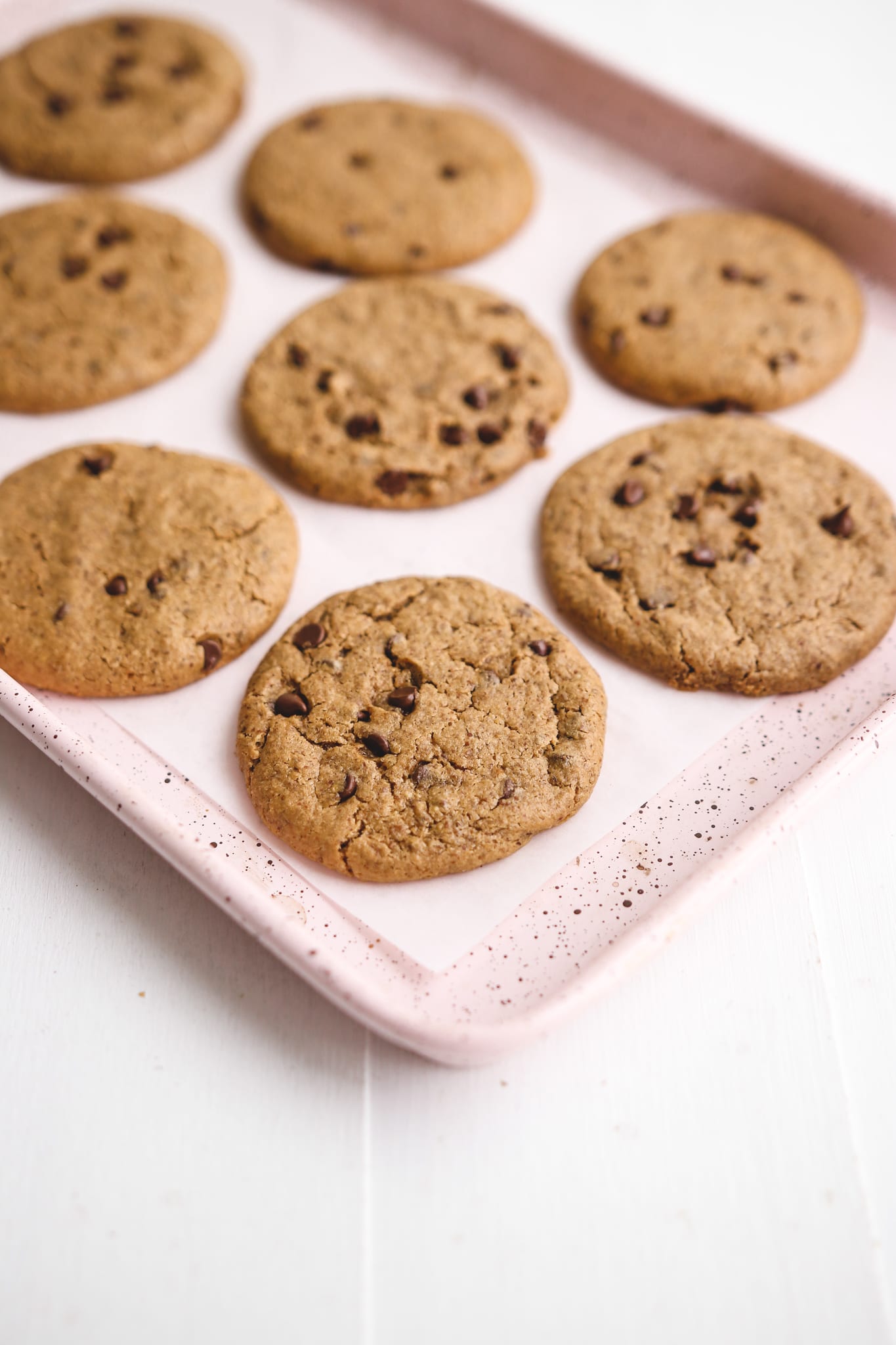 healthy chocolate chip cookies on a pink lined baking sheet