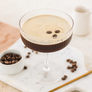 a virgin espresso martini in a coupe glass topped with three coffee beans.