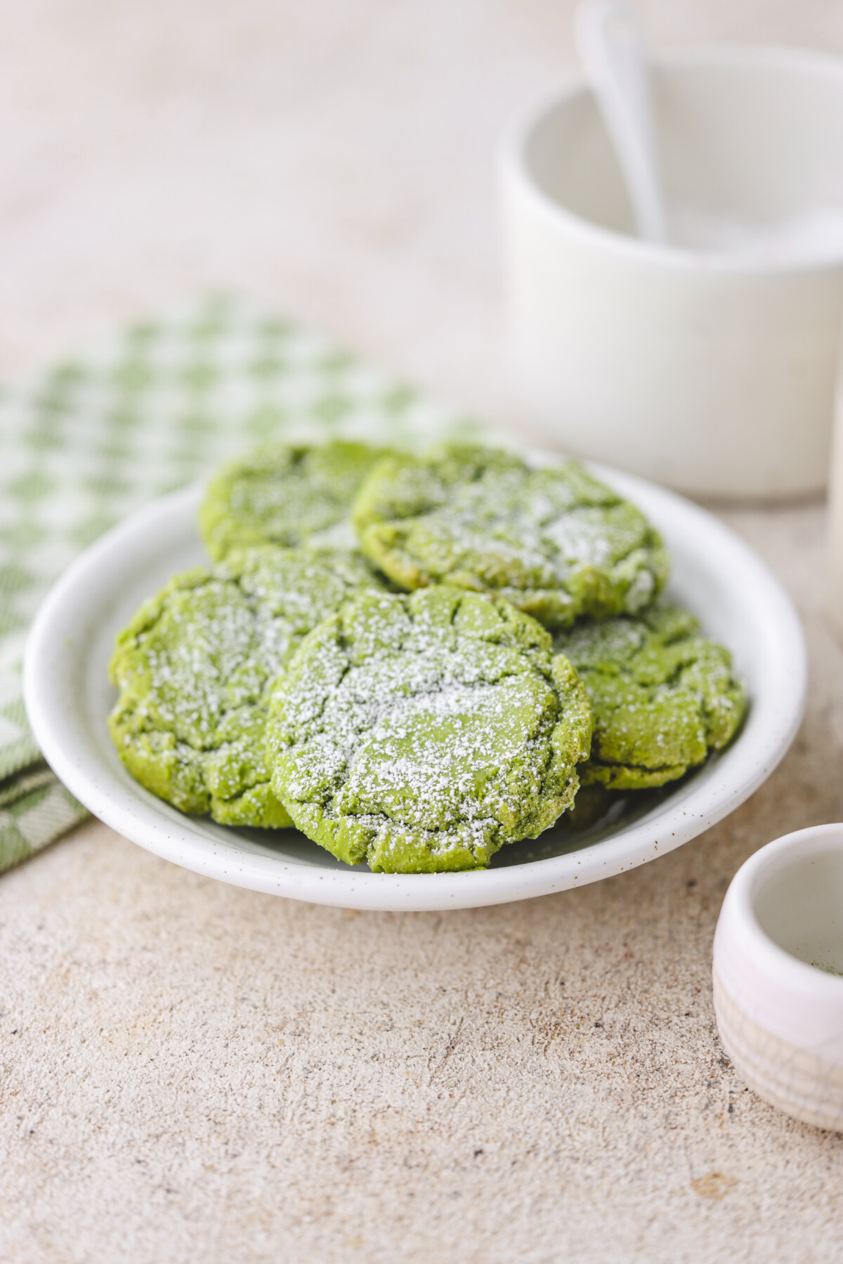 a white plate filled with matcha crinkle cookies