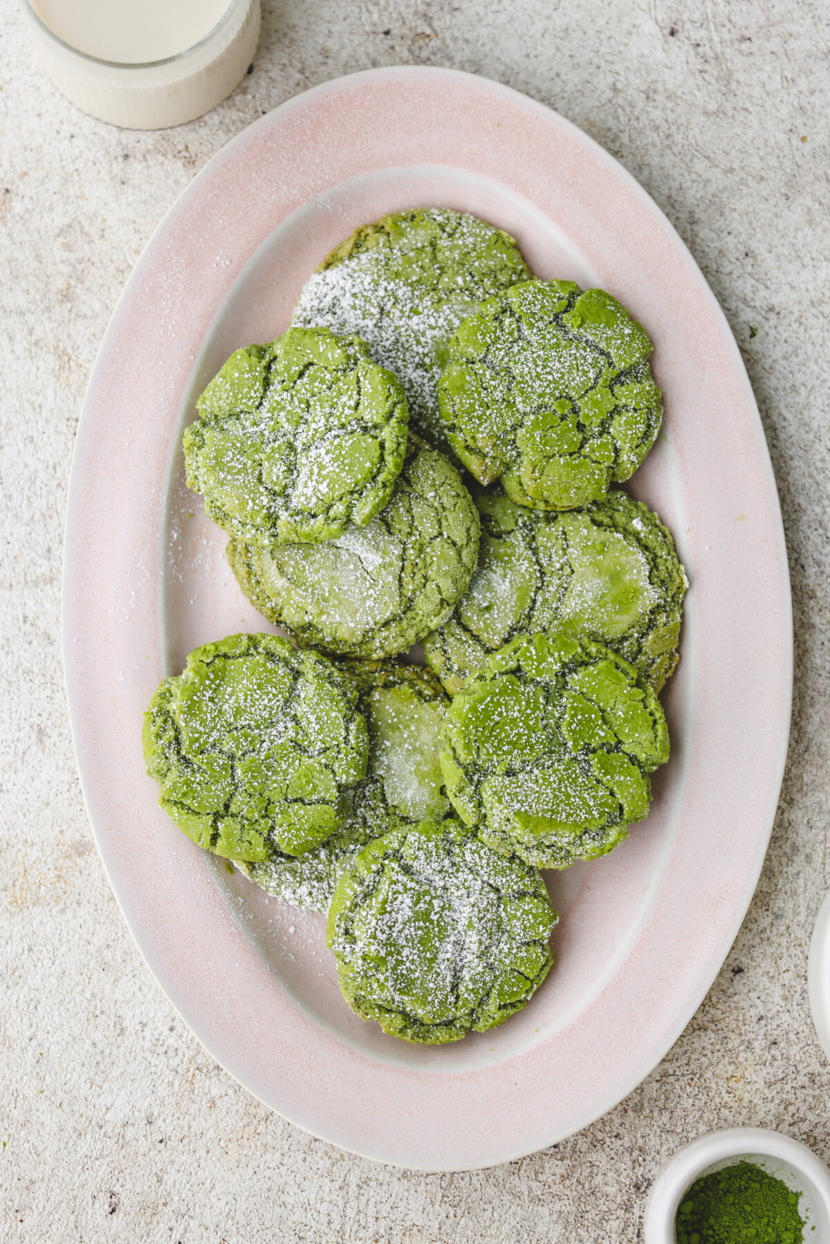 a pink platter of matcha crinkle cookies