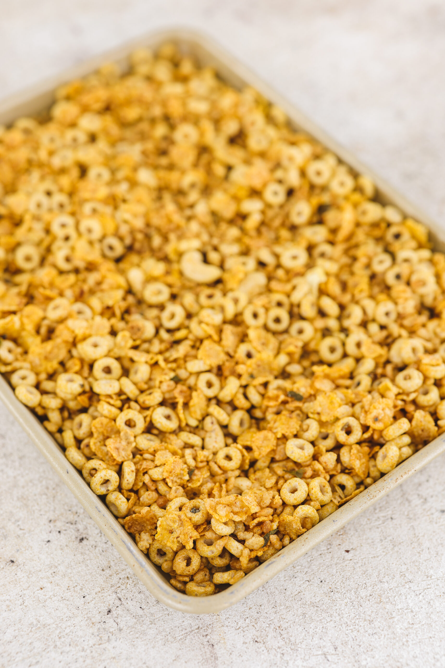 a baking sheet filled with toasted cereal