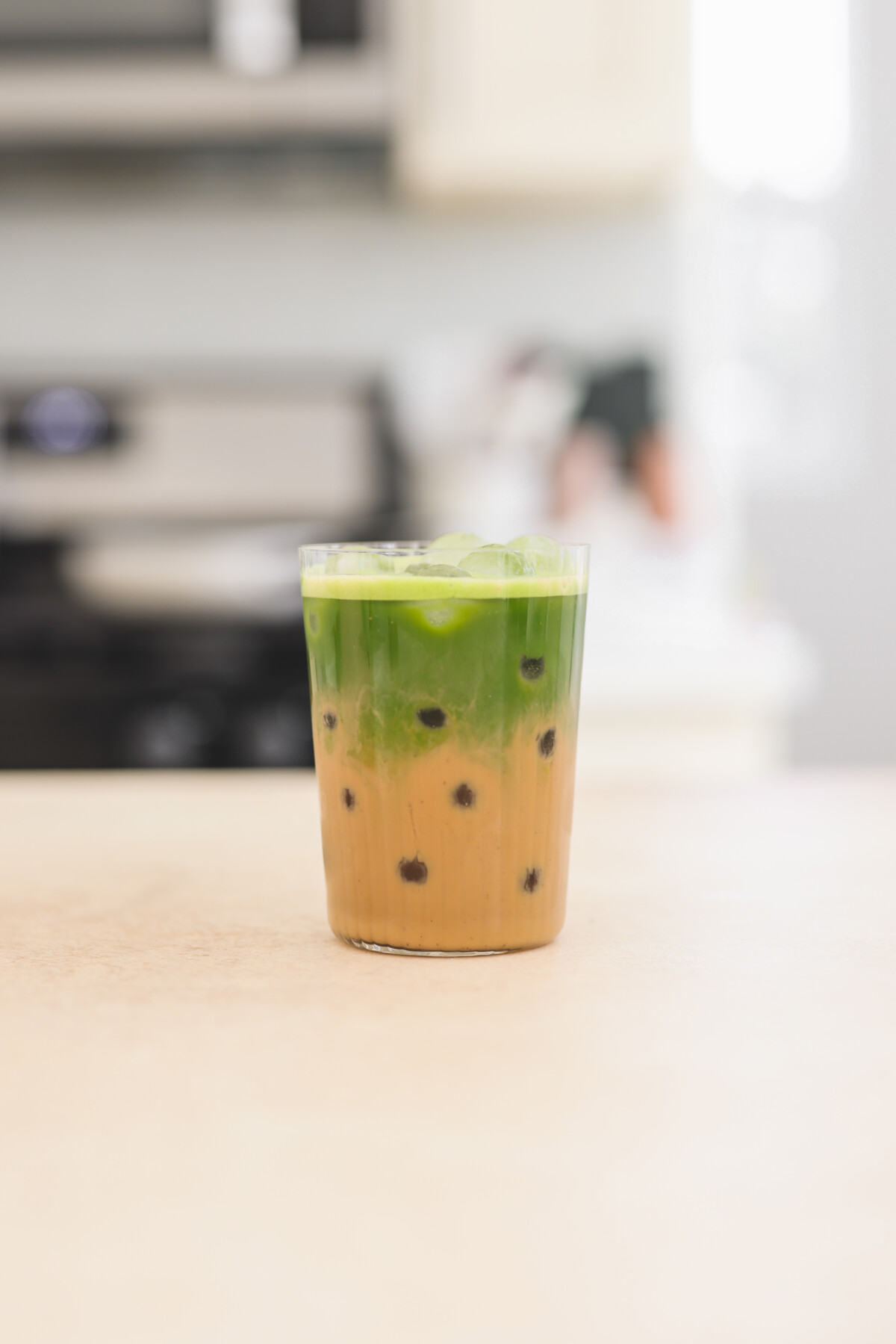 a glass filled with an iced matcha chai latte
