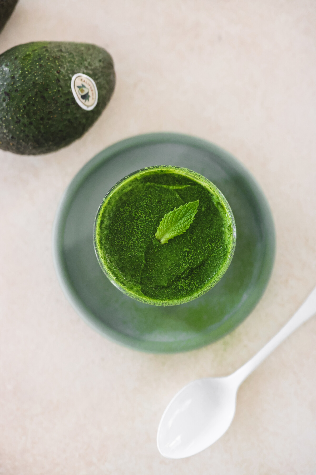 an overhead shot of matcha mousse in a small glass jar. 